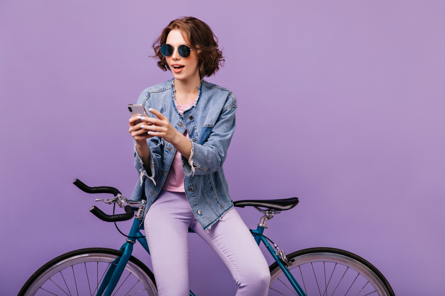 Persoon met fiets op paarse achtergrond