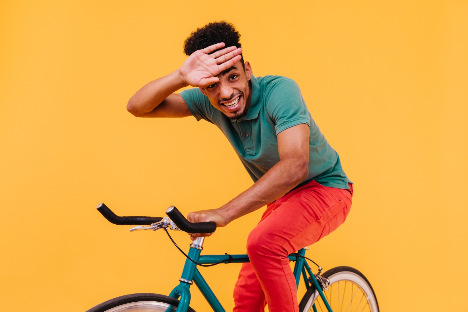 Persoon op fiets op gele achtergrond
